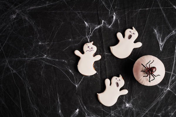 White Pumpkin and Cookies in the Form of Ghosts Are on Halloween Table